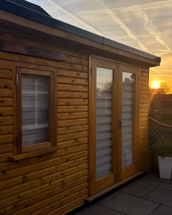 Nicky’s Wellness Retreat, a wooden garden room with French doors, at sunset