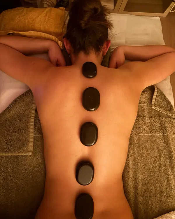 Warm stones placed along a client’s back during a hot stone massage